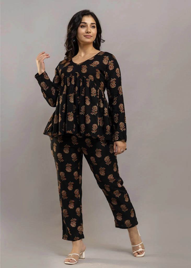 Women’s black co-ord set in soft rayon, featuring rustic floral prints, a full-sleeve flared top with a relaxed silhouette, and matching straight-fit pants — combining effortless elegance with everyday comfort.