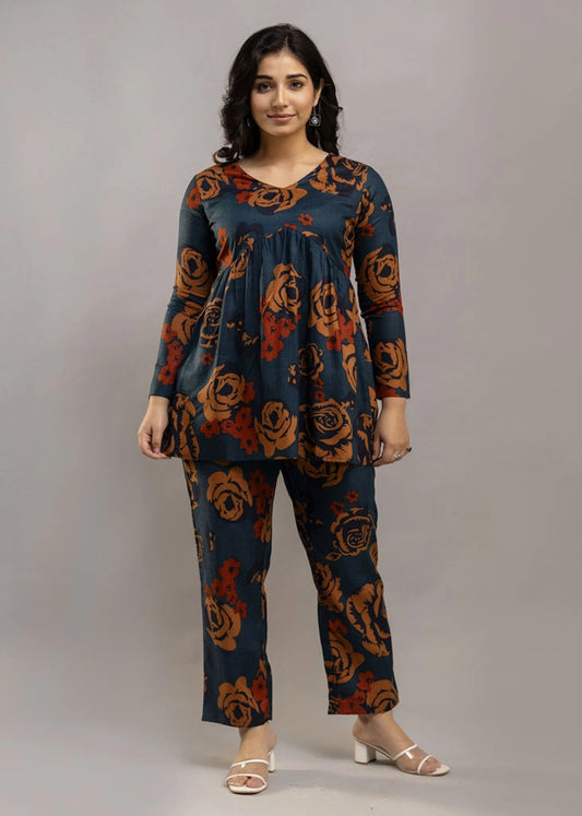 Women’s teal and rust floral printed co-ord set in premium rayon, featuring a flowy gathered top with relaxed flared full sleeves and matching straight-fit pants — a soft, breathable outfit that blends bold style with everyday comfort.