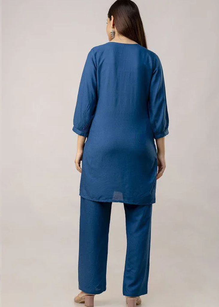 Women’s blue solid straight-fit kurta and pant set in viscose rayon, featuring floral embroidery on the front, a round neckline, three-quarter sleeves, above-knee length, paired with matching embroidered slip-on trousers with an elasticated waistband.