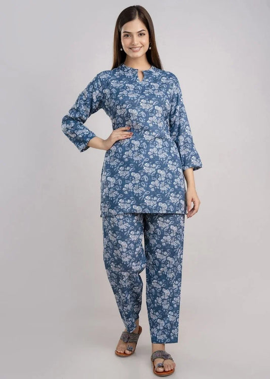 Women’s pastel green cotton-blend kurti and pant set with a round neckline, three-quarter sleeves, floral block print, straight ankle-length pants, and a relaxed A-line silhouette.