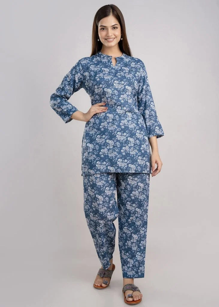 Women’s pastel green cotton-blend kurti and pant set with a round neckline, three-quarter sleeves, floral block print, straight ankle-length pants, and a relaxed A-line silhouette.