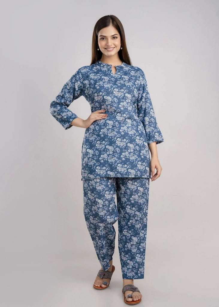 Women’s pastel green cotton-blend kurti and pant set with a round neckline, three-quarter sleeves, floral block print, straight ankle-length pants, and a relaxed A-line silhouette.