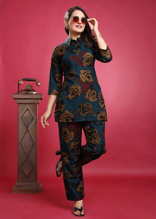 Women’s blue viscose rayon co-ord set featuring a collared top with 3/4 sleeves and vibrant yellow and red floral embroidery, paired with matching pants — a breezy, elegant outfit for casual or semi-formal wear.