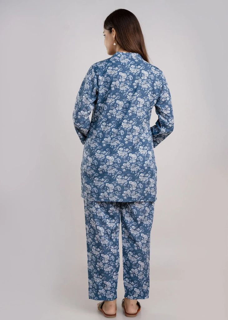 Women’s pastel green cotton-blend kurti and pant set with a round neckline, three-quarter sleeves, floral block print, straight ankle-length pants, and a relaxed A-line silhouette.