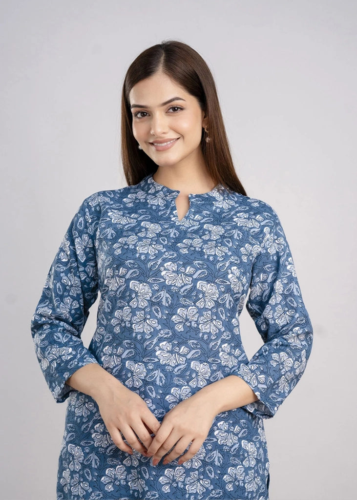Women’s pastel green cotton-blend kurti and pant set with a round neckline, three-quarter sleeves, floral block print, straight ankle-length pants, and a relaxed A-line silhouette.
