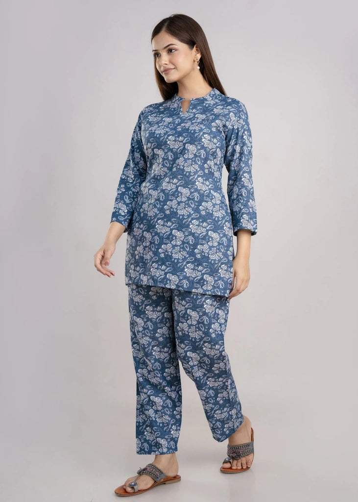Women’s pastel green cotton-blend kurti and pant set with a round neckline, three-quarter sleeves, floral block print, straight ankle-length pants, and a relaxed A-line silhouette.