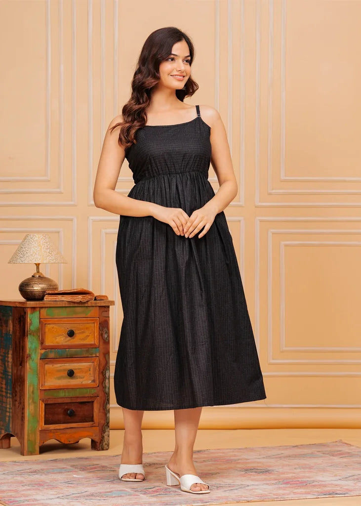 Sleeveless black maxi dress for women, featuring a flared floor‑length silhouette with a square neckline and airy drape, crafted from lightweight fabric for an elegant, flowing fit.