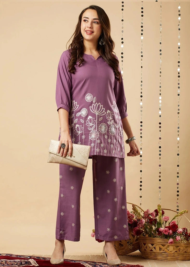 Women's lavender kurta-and-pant set in lightweight fabric, featuring intricate white floral embroidery across the front, with a round neckline, three-quarter sleeves, straight pants, and a streamlined, elegant silhouette.