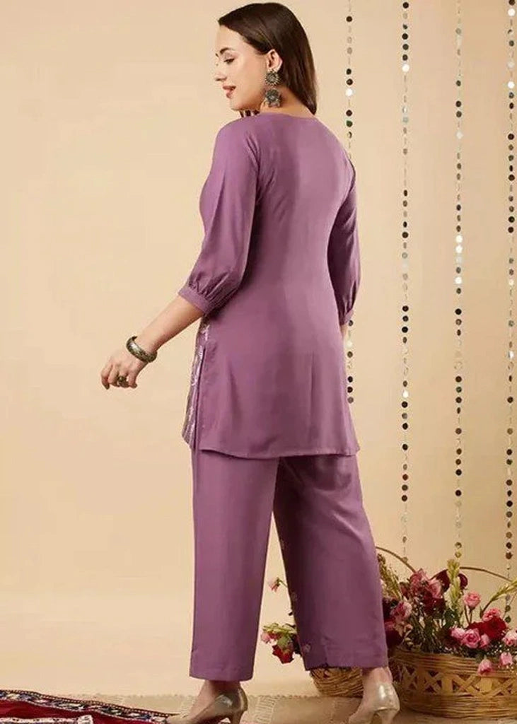 Women's lavender kurta-and-pant set in lightweight fabric, featuring intricate white floral embroidery across the front, with a round neckline, three-quarter sleeves, straight pants, and a streamlined, elegant silhouette.